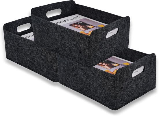 Twee donkergrijze vilten opbergmanden met tijdschriften erin, een op de andere.