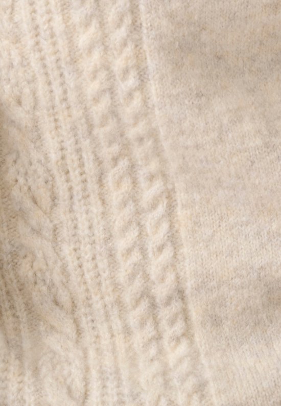 Detail van beige gebreide stof met kabelpatroon.