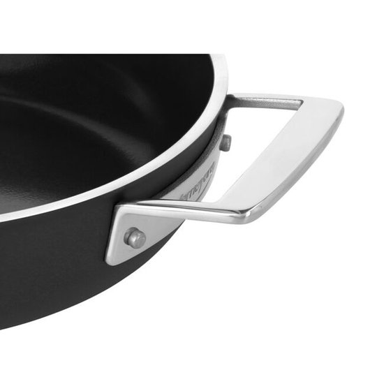Detail van een zilveren handvat aan een zwarte pan.
