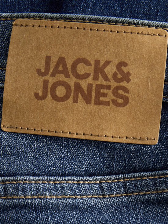Bruin leren label van Jack & Jones op de achterkant van een blauwe jeans.