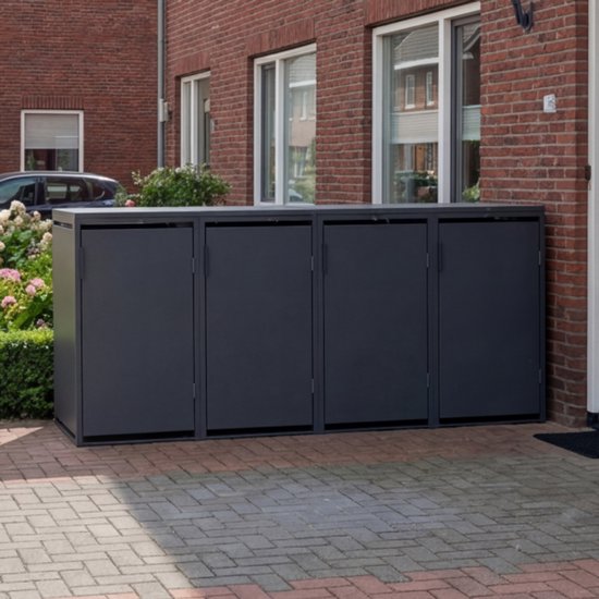 Donkergrijze kliko ombouw van vier vakken, geplaatst op een bakstenen oprit naast een bakstenen huis.