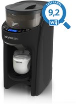 Zwarte Baby Brezza Formula Pro Advanced flesmaker met een glazen fles met witte melk en "Testpanel 9,2 wij" logo.