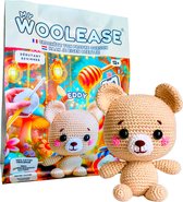 Gehaakte teddybeer "Eddy" naast de verpakking van het My Woolease haakpakket.