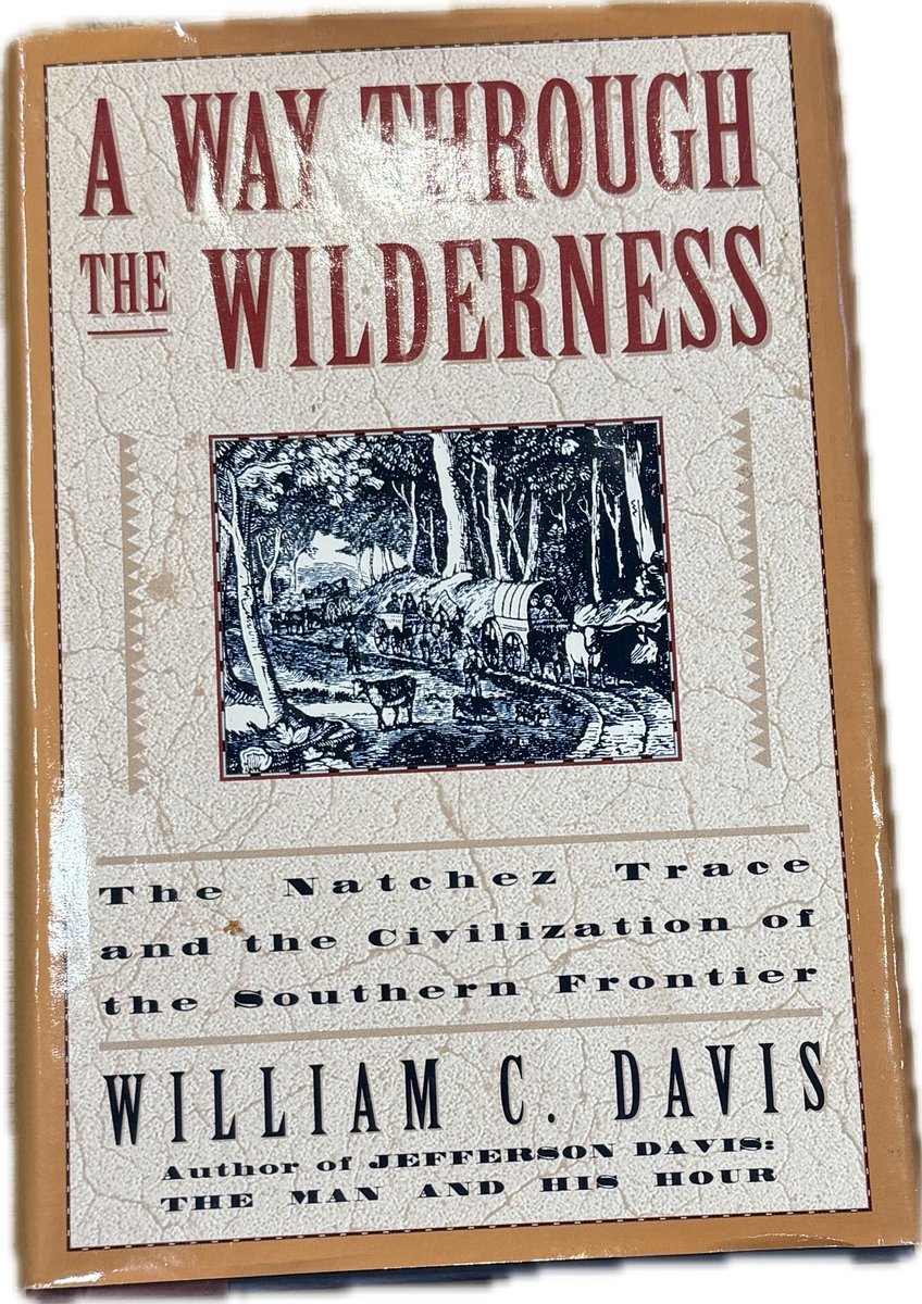 Boek met de titel "A Way Through the Wilderness", met een illustratie van een pionierskaravaan in een bos.