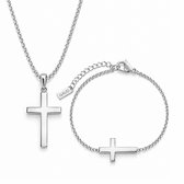 Zilverkleurige ketting met kruis en armband met liggend kruis. Het label 'GAUD' is zichtbaar op de armband.
