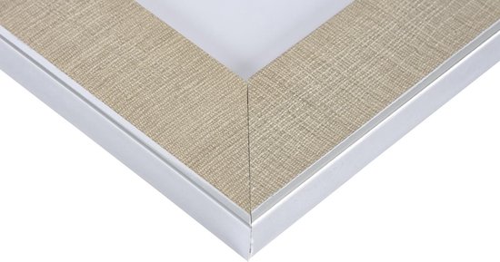 Een close-up van de beige linnen rand van een zilverkleurige fotolijst.