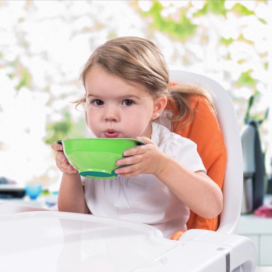 Meisje in kinderstoel met groen en blauw babykommetje.