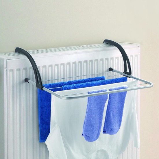 Zilverkleurig droogrek met zwarte ophangarmen, gebruikt op een radiator met wasgoed.