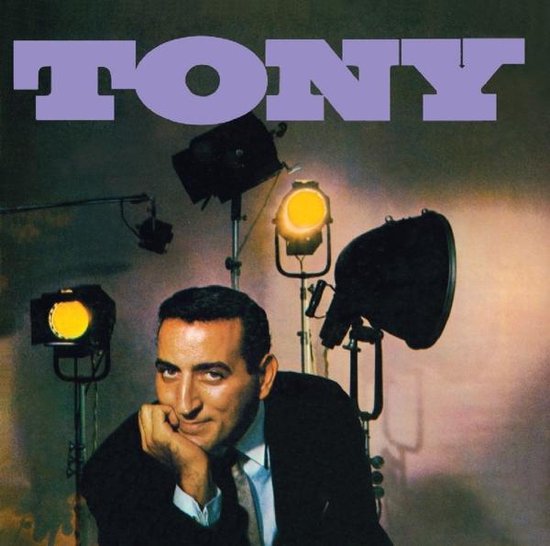 Man met de hand op de kin, in de spotlights, met het woord TONY erboven.
