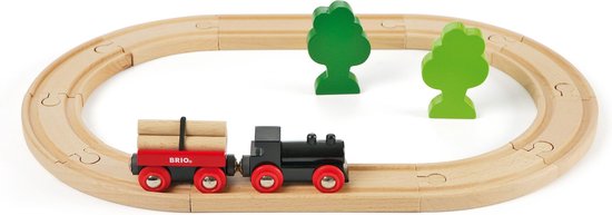 Zwarte houten trein met rode wagon vol houtblokken op een ovalen houten treinbaan, met twee groene bomen.