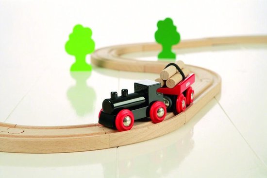 Zwarte locomotief met rode wielen, sleep een rode wagon met houtblokken over een houten treinbaan, met twee groene bomen.