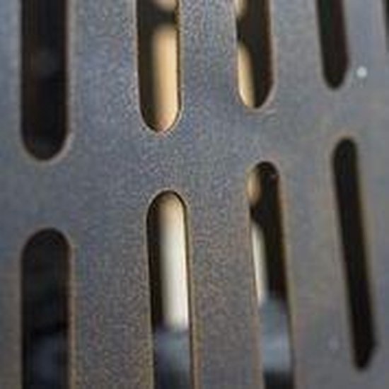 Close-up van een donkere metalen vuurkorf met openingen.
