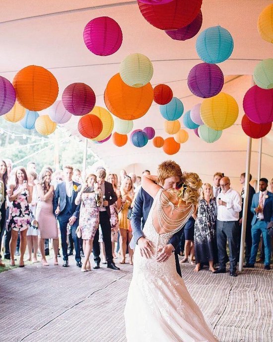 Bruidspaar danst onder veelkleurige lampionnen.