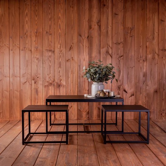 Ensemble de tables basses noires avec une grande table rectangulaire et deux petites tables carrées, disposées sur un plancher en bois.
