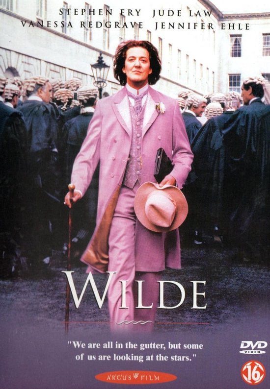 Stephen Fry als Oscar Wilde in een roze kostuum, met hoed en wandelstok, omringd door rechters.