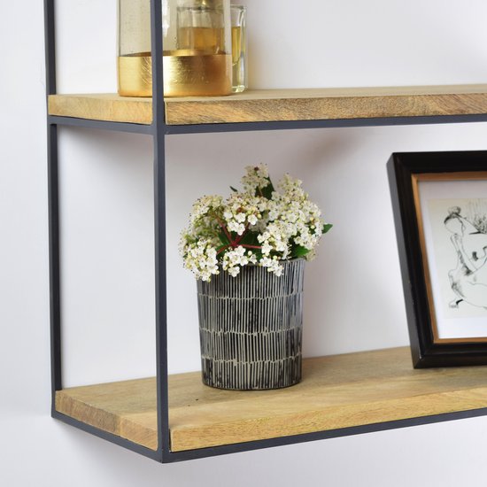 Detail van het wandrek met een vaasje met witte bloemen en een zwart-wit lijstje.