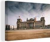 Canvas Schilderij De Duitse Rijksdag onder stormachtige wolken in Berlijn - 60x40 cm - Wanddecoratie