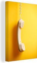 Canvas Schilderij De hoorn van een retro telefoon tegen een gele achtergrond - 60x90 cm - Wanddecoratie