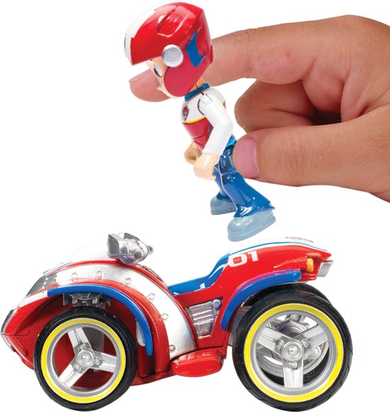 Een hand houdt Ryder figuur boven zijn rode, witte en blauwe ATV speelgoedauto.
