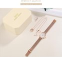 IBSO dameshorloge met rosé-gouden mesh band, ketting en oorbellen op een presentatiekussen, naast een geschenkdoos.