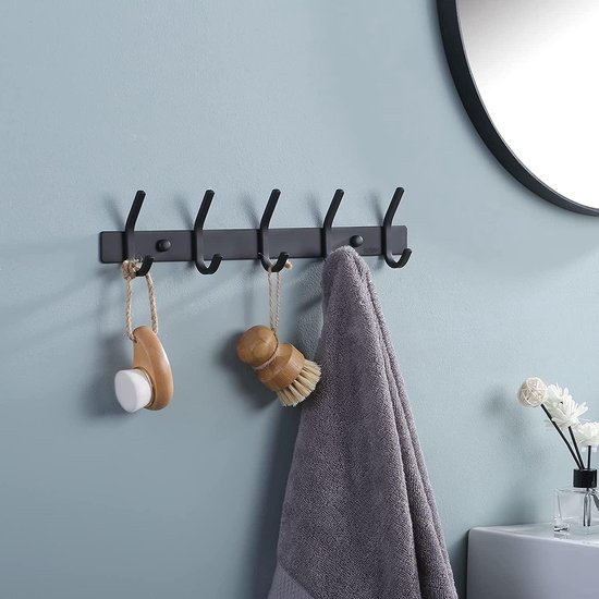 Zwarte wandkapstok met 5 haken in een badkamer, met een grijze handdoek en twee borstels eraan.
