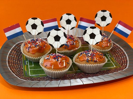 Zes oranje cupcakes met Nederlandse vlaggetjes en voetbalprikkers op een stadion-bord.