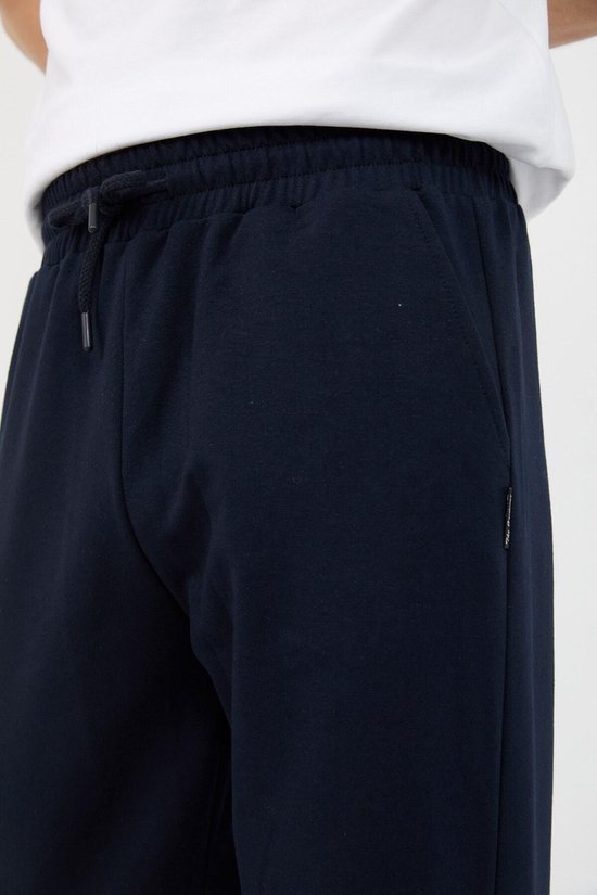 Detail van navy joggingbroek: tailleband met trekkoord en ritszak.
