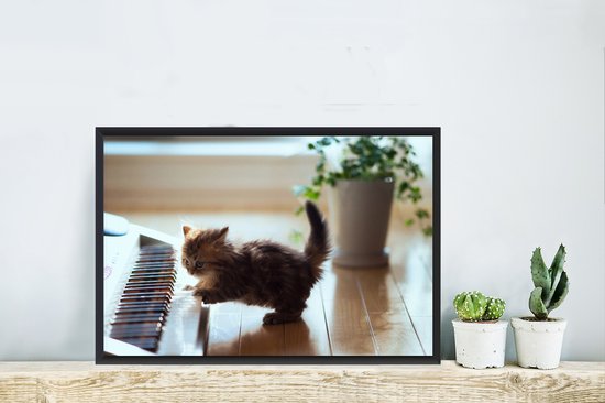 Chaton jouant avec un cadre photo piano noir sans tapis