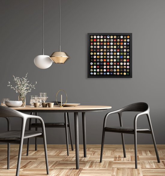 Zwarte lijst met 144 champagnecapsules hangend aan een muur boven een eettafel.
