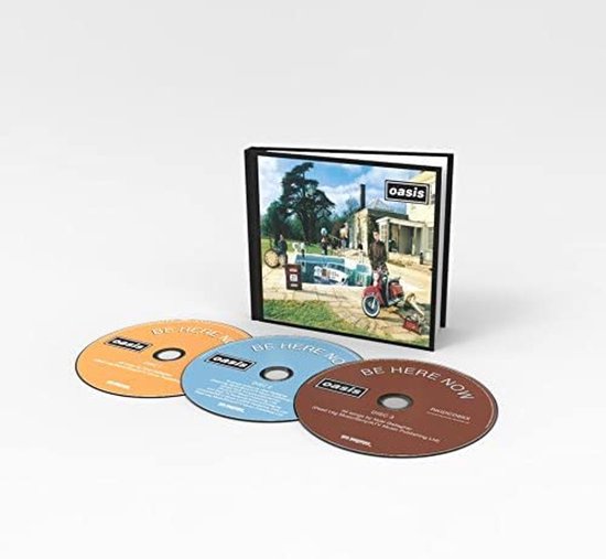 Pochette de CD montrant une scène de piscine avec une Rolls Royce et un scooter. Trois CD sont posés devant : un orange, un bleu et un marron.