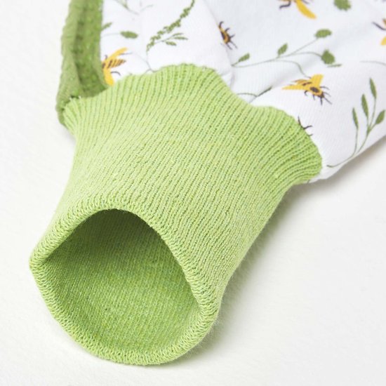 Groene gebreide boord van een tuinhandschoen met een wit met bijen- en bloemenmotief.