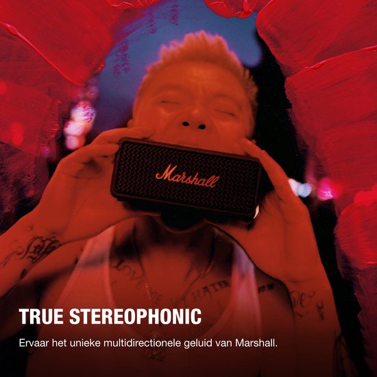 Een persoon houdt een zwarte Marshall-speaker met goudkleurig logo voor het gezicht.