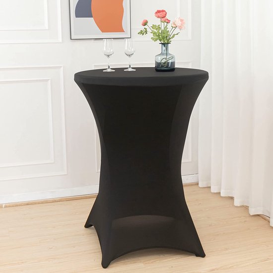 Zwarte statafelrok in een woonkamer met twee glazen en een vaas met bloemen.