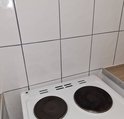 Witte keuken- en wandtegels met grijze voegen boven een fornuis.