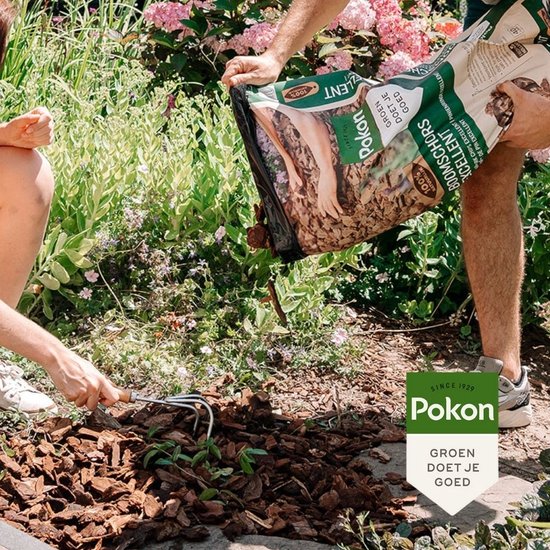 Twee personen vullen de grond met boomschors uit een zak. Groen doet je goed.
