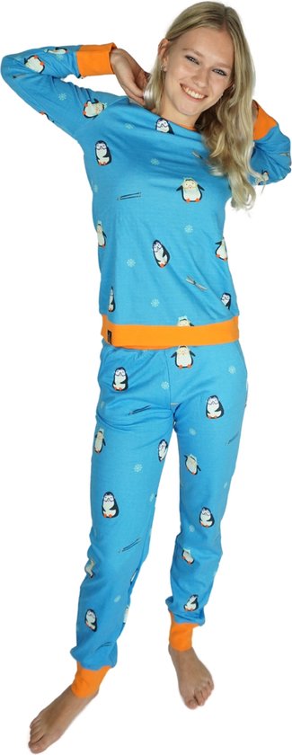 Model in een blauw pyjamapak met pinguïnprint en oranje boorden, staat met handen achter het hoofd.