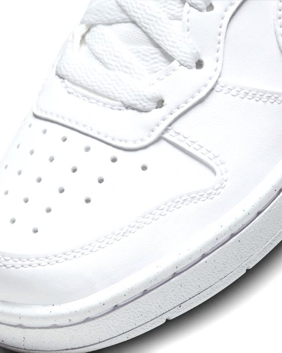 Witte Nike sneaker, detail van de neus met perforaties en stiksels.