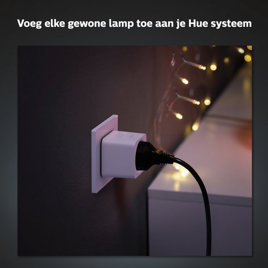 Witte Philips Hue slimme stekker aangesloten op een stopcontact, met een stekker erin.