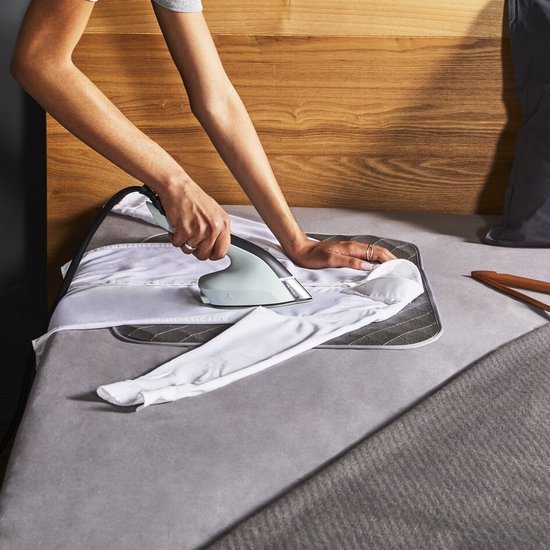 Vrouw strijkt een wit shirt op een grijze strijkplank met het Tefal Duo Power strijkijzer.