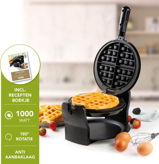 Zwart, roterend wafelijzer met een gemaakte wafel, bessentaart, eieren en receptenboekje.