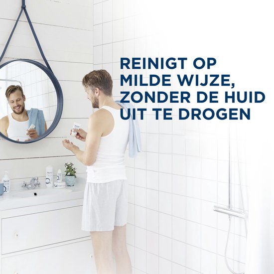 Man in badjas bij de wastafel, kijkt in de spiegel. Reinigt de handen mild.