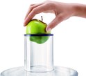 Een groene appel met blauwe rand wordt in een doorzichtige buis gedaan.
