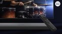 Zwarte soundbar en afstandsbediening, met een tv die een drummer toont. TCL TV Ready logo zichtbaar.