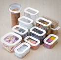 Ensemble de boîtes de rangement Mepal remplies de pâtes, riz, céréales, biscuits, bonbons et croûtons, sur fond en bois.