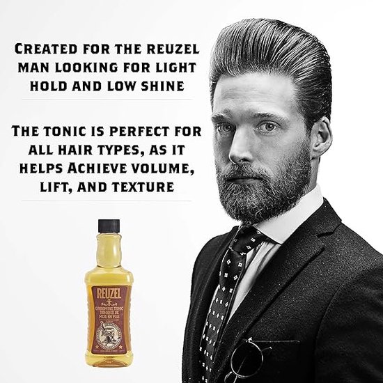 Man met hoge, gelakte coupe en baard, in pak. Reuzel grooming tonic flesje rechtsonder.