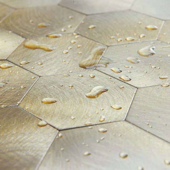 Goudkleurige hexagon tegels met geborsteld metaal effect en waterdruppels.