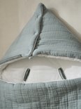 Detail van de puntige capuchon van een lichtblauwe trappelzak van katoengaas met witte binnenkant.