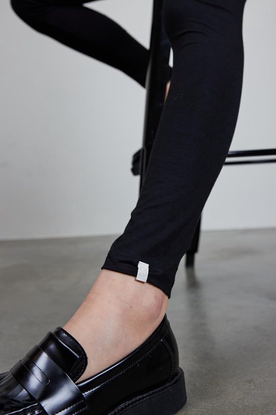 Detail van de enkel en schoen van een zwarte Didi legging.