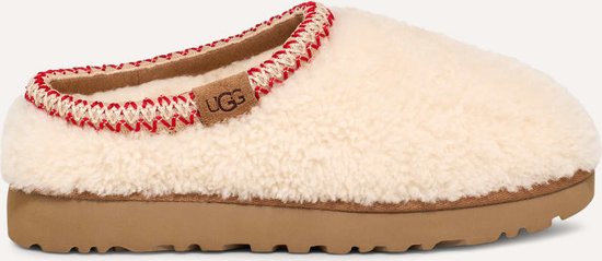 Crème UGG slipper met rode stiksels langs de opening en een bruine zool.