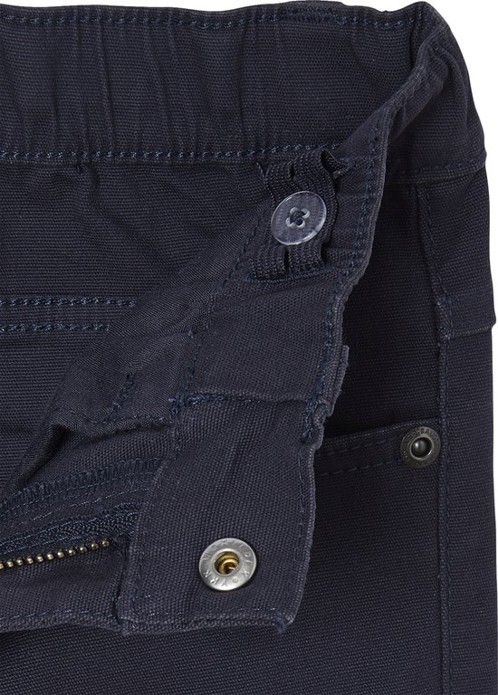 Detail van de knoop- en ritssluiting van een donkerblauwe jongensbroek.